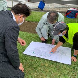 Japan Flying Labs Explaining flight on paper map to Inagi Mayor