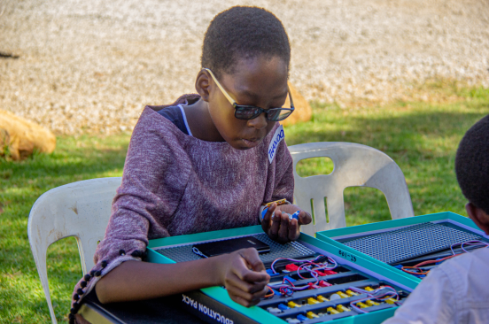 A young girl works on a STEM Kit during Zimbabwe Flying Labs' Drone Club.