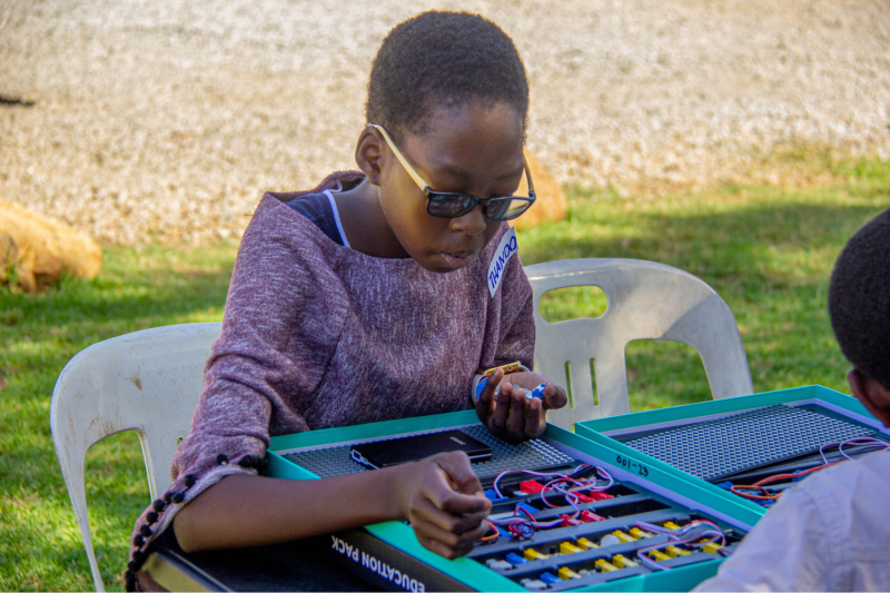 A young girl works on a STEM Kit during Zimbabwe Flying Labs' Drone Club.