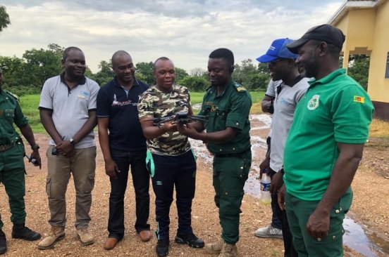 National park personnel watch as a Cameroon Flying Labs team member gives a demonstration using a drone.