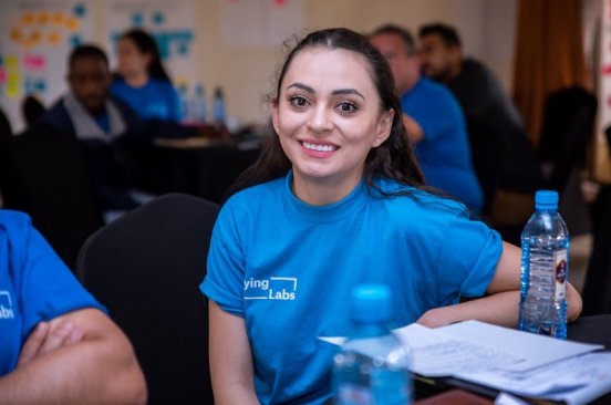 Erika Lopez, wearing a blue Flying Labs tshirt smiles at the camera at the global Flying Labs Network Retreat in 2022