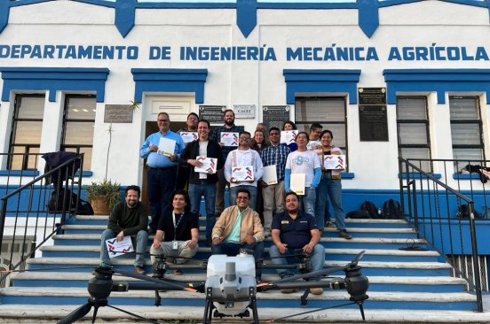 Professors and students from Mexico Flying Labs, Chapingo University, and Uruguay’s Catholic University take a group photo on a short flight of stairs outside a Chapingo University building.