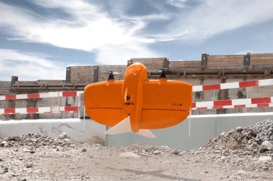 A photo of a bright orange WingtraOne drone used by Ghana Flying Labs for a road reconstruction mapping project.