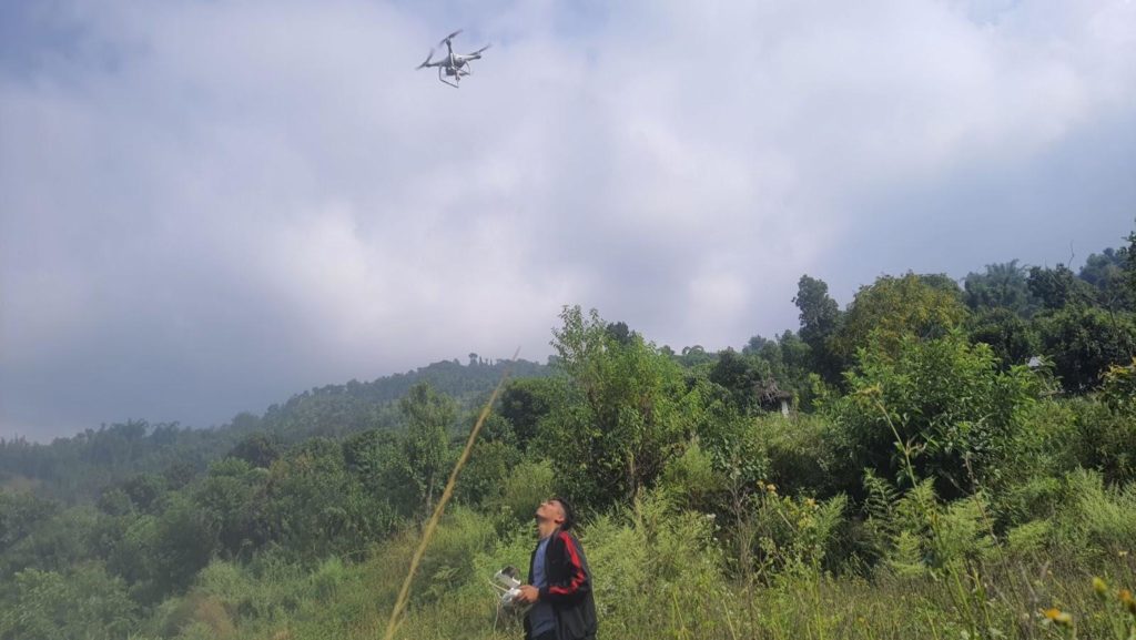 Drone pilot flying a drone while preparing for the mission