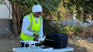 female hijabi drone pilot setting up